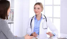 Médica com estetoscópio no consultório