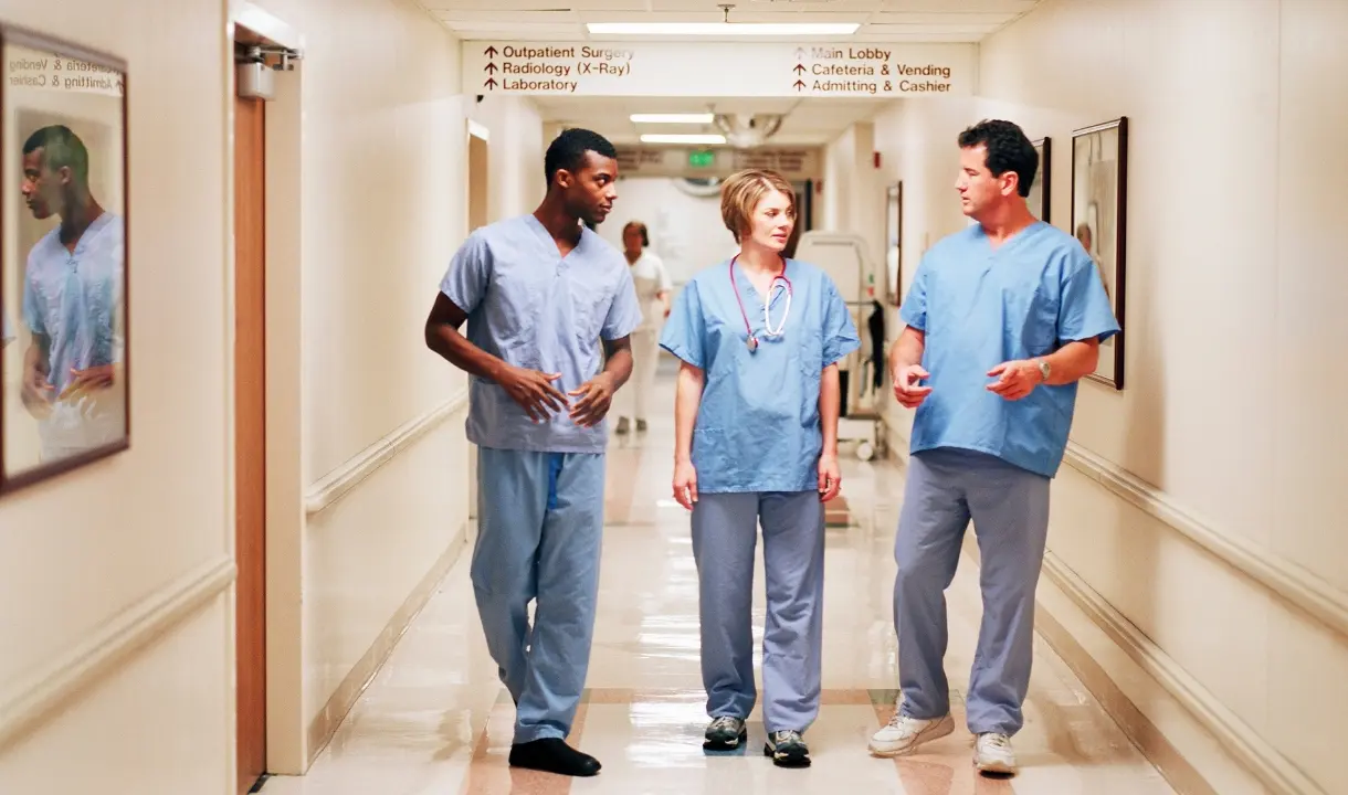 Equipe médica caminhando pelo corredor do hospital