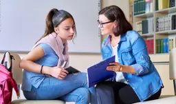 Médica conversando com uma paciente jovem