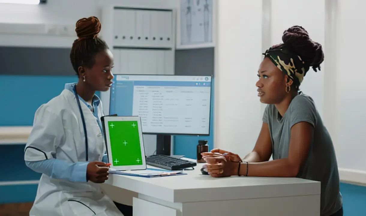 Médica atendendo um paciente com apoio do computador